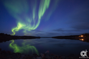 Northern lights reflecting in lake in September. Yellownkife Canada