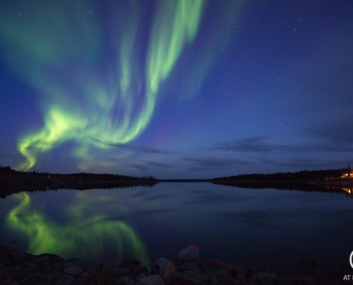 Northern lights reflecting in lake in September. Yellownkife Canada